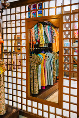 The reflection of traditional colorful cloths sold at an Indonesian batik shop on the tall dressing mirror.