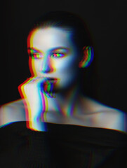 Studio portrait of beautiful woman with wet hairstyle. Model looking away the camera and thinking by holding hand palm near mouth. RGB color split effect applied. Futuristic looking style