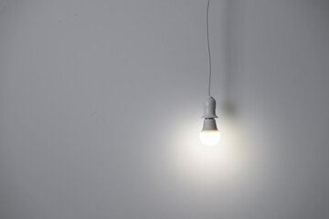 simple light bulb hanging near the wall at home