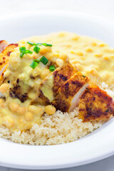 chicken breast served with creamy curry chickpea sauce and couscous