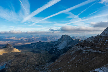 Aerial view of Durmitor national park yellow winter grass on land and top of mountains lake and clouds on sky