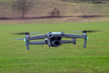 Flying  drone with 4k gimbal camera  hovering over landscape background