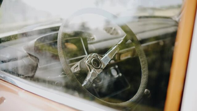 Through the glass you can see the inside of the cab of an abandoned retro car