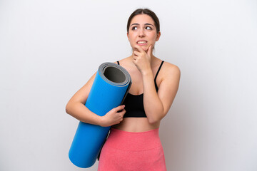 Young sport girl going to yoga classes while holding a mat isolated on white background having...