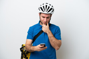 Young caucasian man with thermal backpack isolated on white background thinking and sending a message