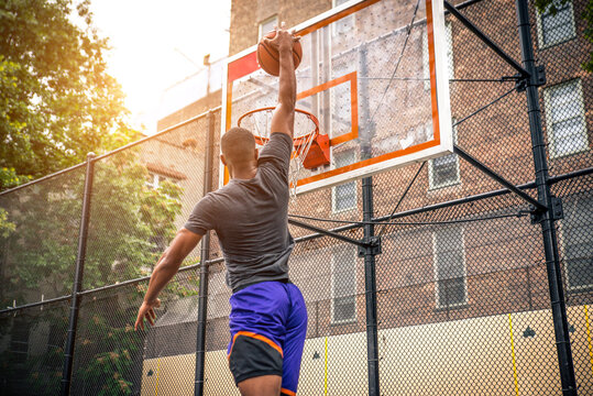 Athletic african american basketball player training on a court in New York - Sportive man playing basket outdoors