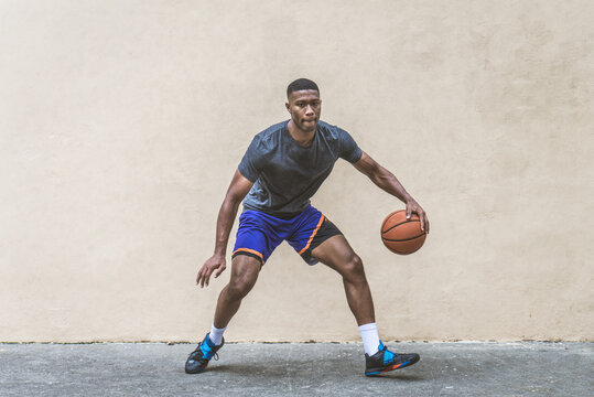 Athletic african american basketball player training on a court in New York - Sportive man playing basket outdoors - Powered by Adobe