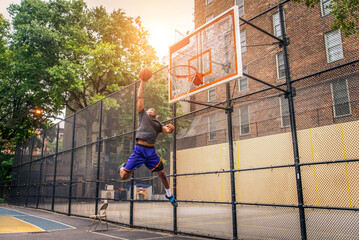 Athletic african american basketball player training on a court in New York - Sportive man playing basket outdoors © oneinchpunch