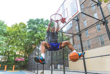 Athletic african american basketball player training on a court in New York - Sportive man playing...
