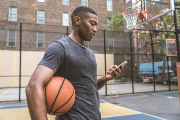 Athletic african american basketball player training on a court in New York - Sportive man playing...