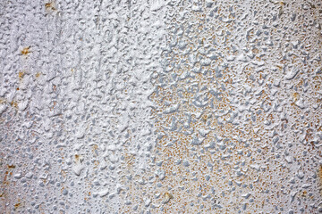 Texture of paint stains on the wall, cracked paint on an old metal surface. Sheet of silver metal with cracked and peeling paint, background for design with copy space.