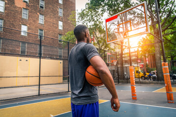 Athletic african american basketball player training on a court in New York - Sportive man playing...