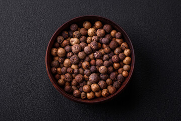 Spice allspice brown color not ground in a wooden saucer. Asian food - obrazy, fototapety, plakaty