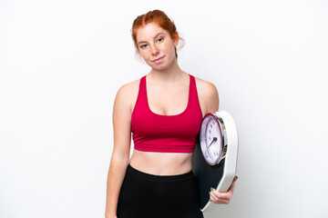 Young reddish woman isolated on white background with weighing machine