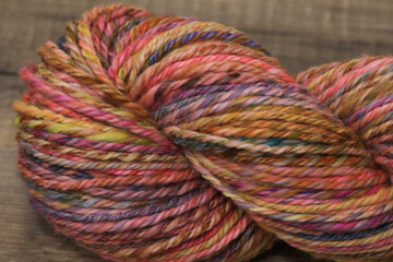 Closeup of colourful handspun and handdyed pure organic merino sheep wool yarn , spun on a spinning wheel