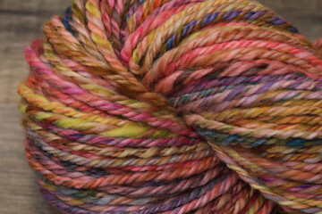 Closeup of colourful handspun and handdyed pure organic merino sheep wool yarn , spun on a spinning...