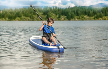 active teen girl paddling a sup board on a river or lake, natural background, active healthy sporty lifestyle