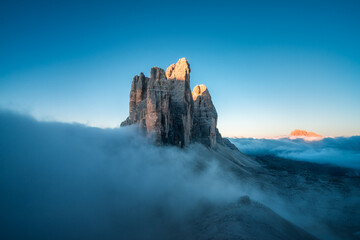 Felsmassiv, die Drei Zinnen, in den Dolomiten in Südtirol in den Alpen mit Fels im Sonnenlicht und Nebel.