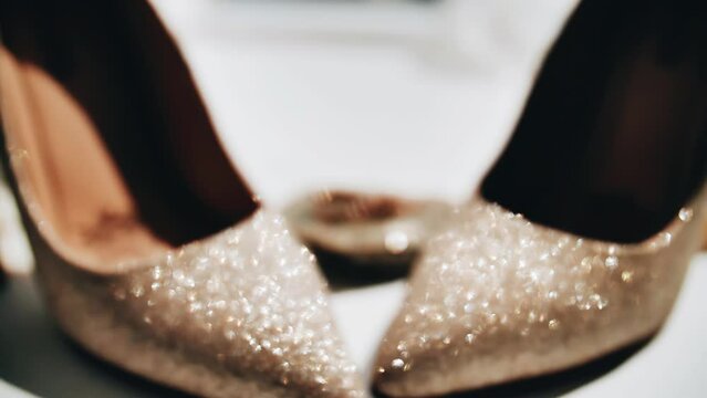 Close-up of women's shoes and gold rings. Shooting objects in motion