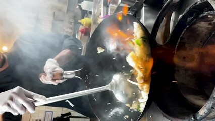 close up of a wok in slow motion, with the ingredients and fire, vertical video - Powered by Adobe
