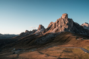 Fototapeta premium Passo Giau in den Dolomiten mit Passstraße und Gipfel mit Sonne.