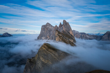 Nebelmeer um Felsmassiv in den Alpen.