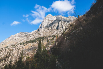 Kotor, Montenegro, process of climbing to the top of San Giovanni Fortress, Fort St. John, old medieval town, hiking on the Ladder of Kotor, sunny day with a blue sky and mount Lovcen and Orjen