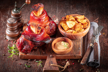 Hot roasted pork knuckle on a plate with baked potatoes.