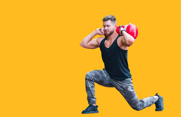 Handsome young athlete working out on a running track. Young man doing squats with a heavy 10 kilo bag on the track. Sport and wellbeing concept. Closeup.