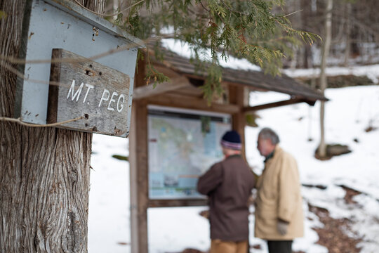 Two men study the trail map for mt peg.
