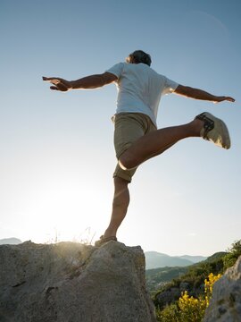Man leaps onto rock above sea