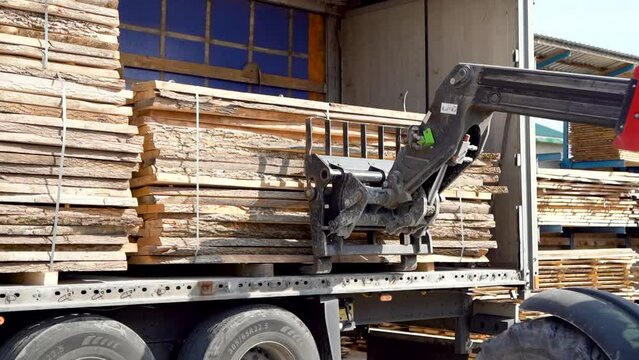 Forklift Uploads Heavy Truck With Wood Block Stacks At Sawmill. Oak Boards