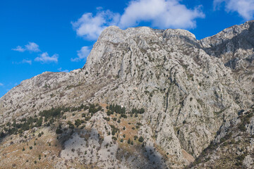 Kotor, Montenegro, process of climbing to the top of San Giovanni Fortress, Fort St. John, old medieval town, hiking on the Ladder of Kotor, sunny day with a blue sky and mount Lovcen and Orjen