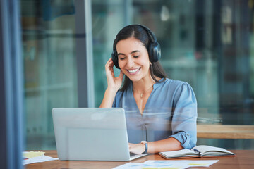 Business woman, laptop and headphones for music while working at office desk, agency or company....