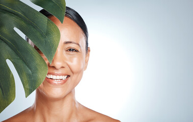 Skincare, leaf and portrait of woman in studio for skin, product and natural treatment on grey...