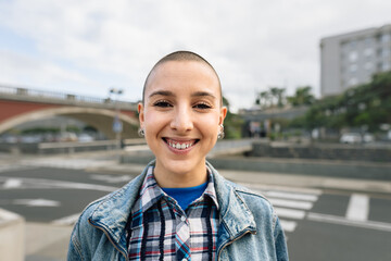 Shaved head girl smiling in front camera
