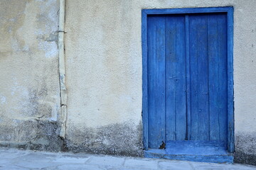 old blue wooden door, wall with peeling paint