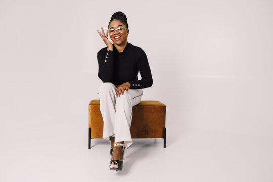 Beautiful Business Woman Sitting On Sofa Chair Smiling And Looking At Camera With Hand On The Face