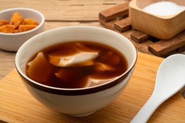Boiled Soft tofu pudding (soy bean curd) in ginger juice soup in a bowl