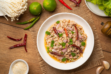 Thai spicy salad with Golden Needle Mushroom and minced Pork in white plate.Top view