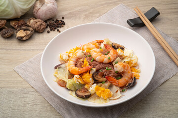 Stir Fried Brown Rice Vermicelli with Prawns ,eggs ,cabbage and dried shiitake mushrooms in white plate