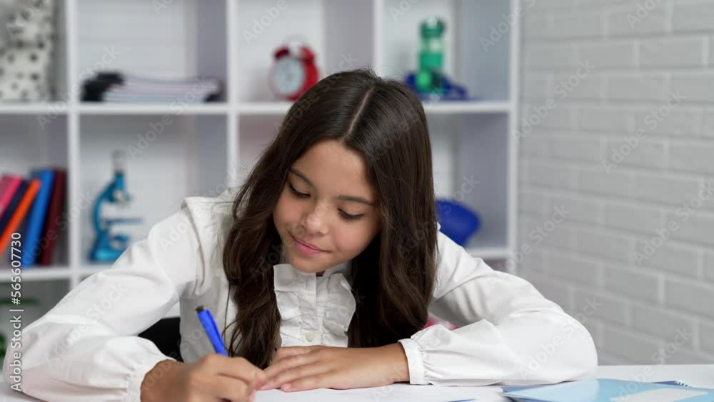 Canvas Prints serious child writing in notebook concentrated on homework with smile, exam preparing