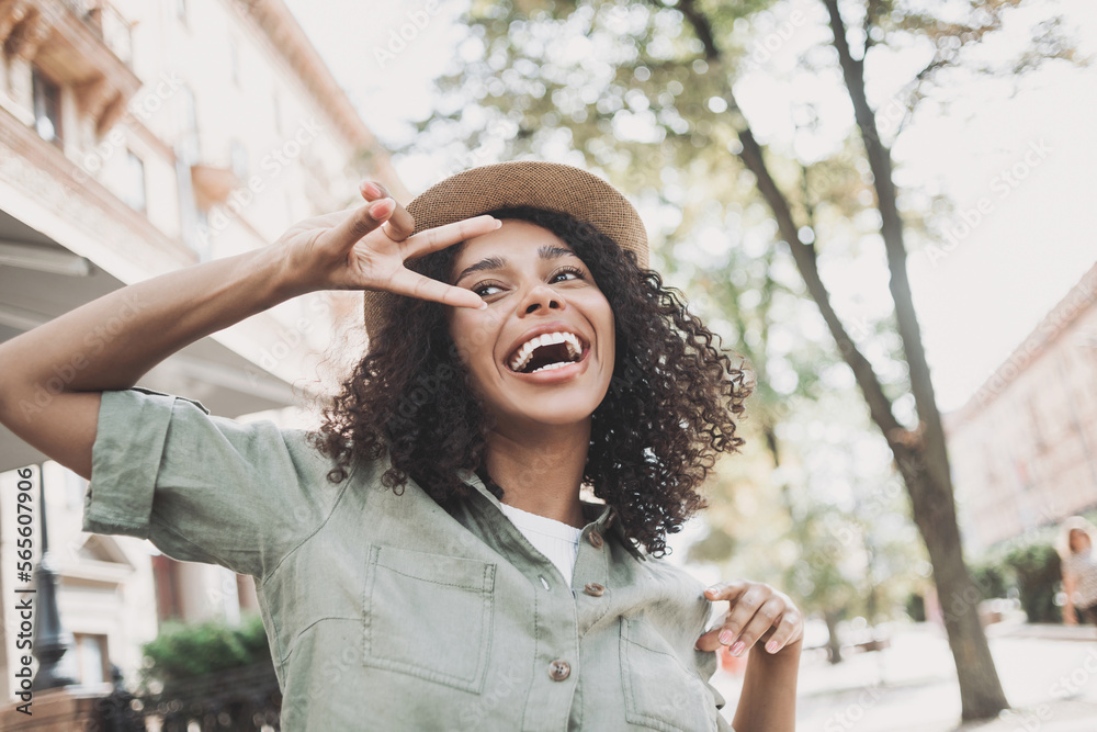 Wall mural young beautiful woman portrait, happy african american student girl smiling in a city, people enjoy 