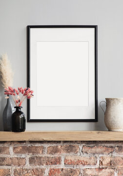 Blank picture frame mockup on gray wall. Modern living room design. View of modern loft style interior, minimalism concept. Vertical template for artwork, painting, photo or poster