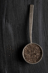 Big old spoon with chia seeds on black background