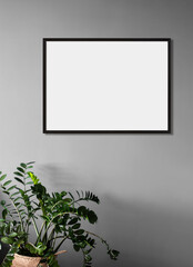 Fototapeta na wymiar Blank frame mockup in modern interior design with trendy plant on empty gray wall background, Black horizontal template for painting, photo or poster. Artwork mock-up