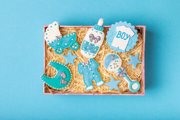 Set of delicious baby shower cookies in a gift box on a blue background. Gender cookies.Baby shower party. Close-up. Flat lay. Place for text.