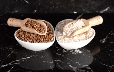 Wooden spoons in bowls with rice and buckwheat. general view