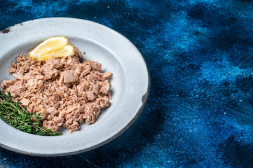 Canned Tuna chunks in olive oil ready for eat. Blue background. Top view. Copy space