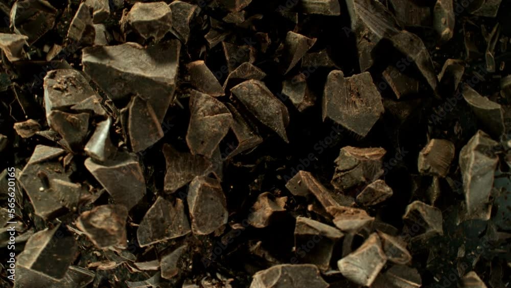 Poster super slow motion of rotating group of raw chocolate pieces. super fast camera motion. filmed on hig